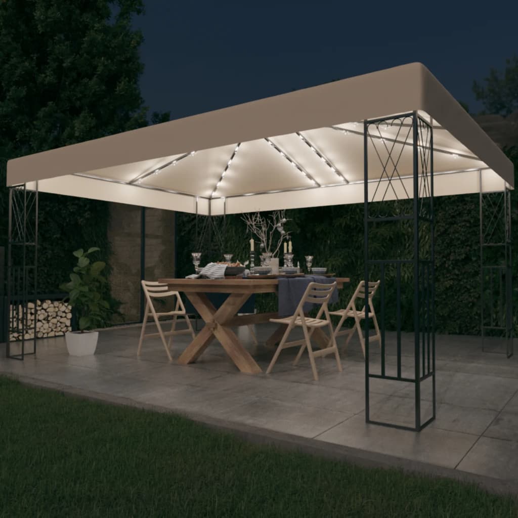 Verlicht prieel met gedekte tafel in de avondtuin